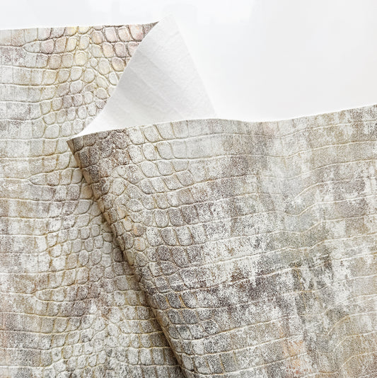 Textured reptile croc vinyl in cream and beige colors for bag making on a white background