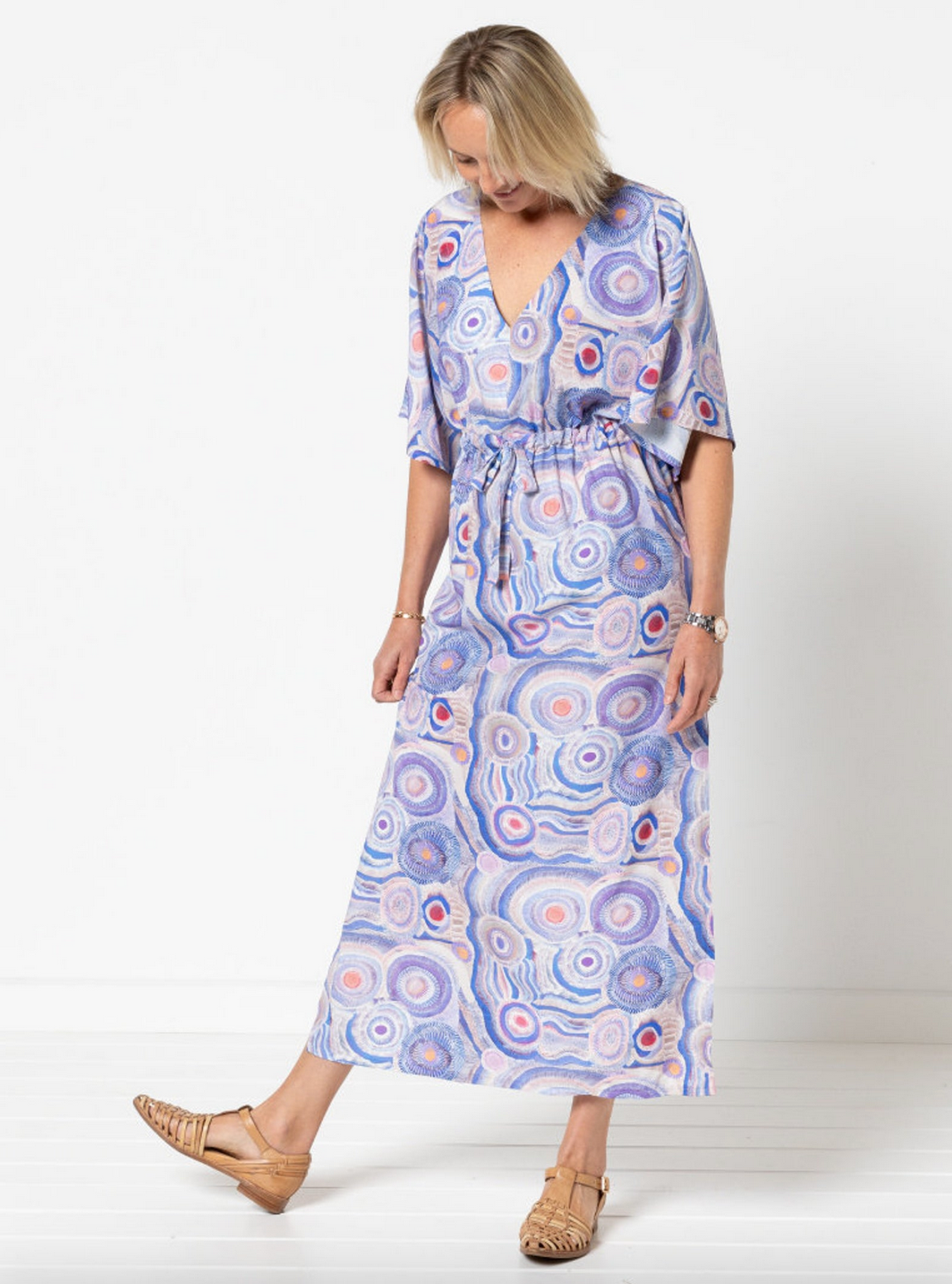 Woman wearing a patterned dress on a white background