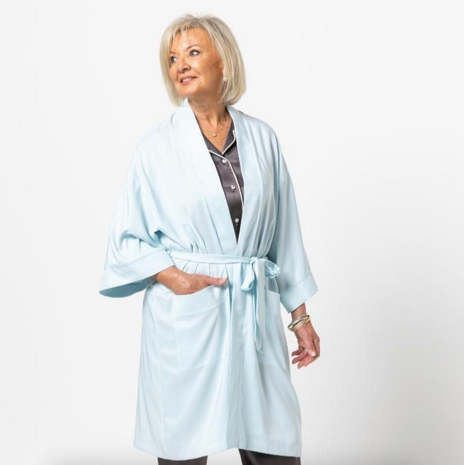 Woman wearing a light blue robe on a white background