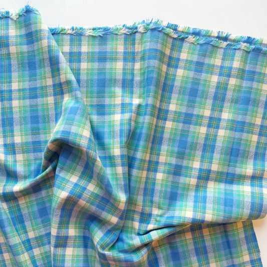 Blue and green plaid fabric on a white background