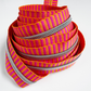 Number 5 continuous zipper tape featuring a bright pink and orange jacquard woven stripe pattern with metallic silver coil teeth, coiled neatly against a white background.