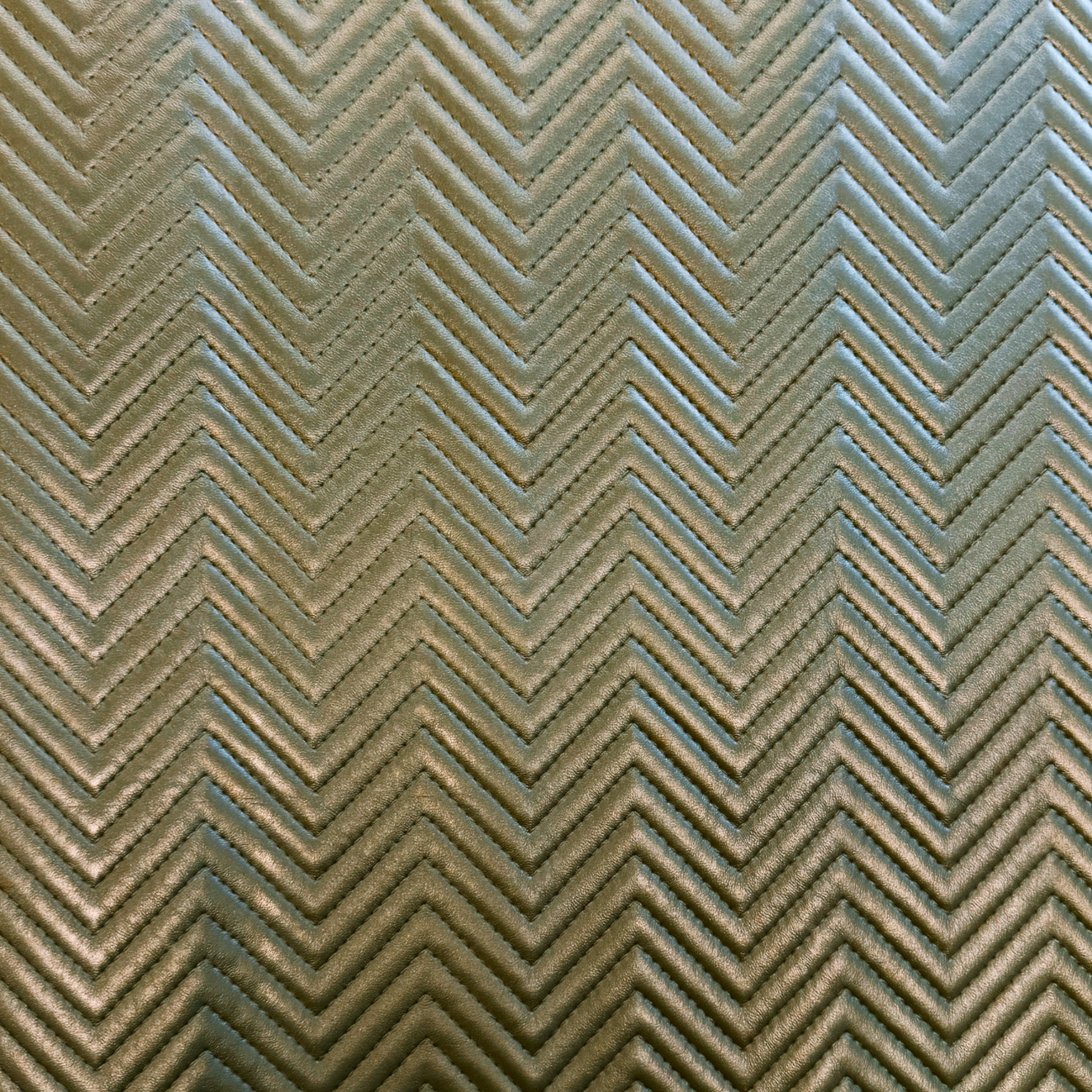 High-definition close-up of embossed zigzag quilted vinyl material featuring dimensional texture, flexible backing, and premium faux leather finish.