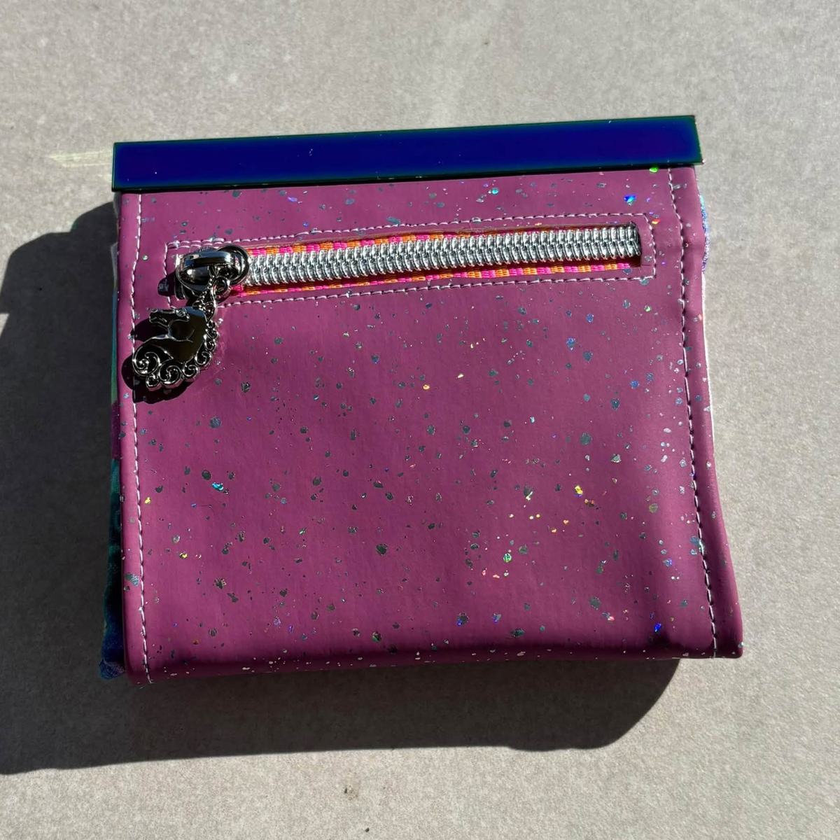 Purple mauve sparkle vinyl pouch with a silver zipper and charm
