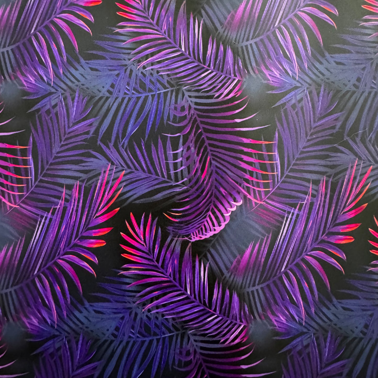 Neon palm leaf pattern on a dark background