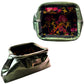 An olive green cosmetic pouch shown from two angles: a top-down view displaying a colorful floral-patterned interior, and a three-quarter view showing a metallic gold brand plaque that reads 'J'adore'.