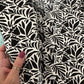 Black and white floral patterned fabric held by a hand
