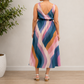Back view of a woman modeling a V-neck midi dress made with Daydream Rayon Geometric fabric in Pale Twilight. The shot highlights the flowy skirt and the continuity of the retro blue, pink, and mustard geometric stripe pattern across the back.