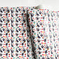 Fiesta Sugar Skulls Printed Vinyl Fabric from Sew Hungryhippie, featuring a festive Day of the Dead (Día de los Muertos) pattern with skeletal figures and animals.