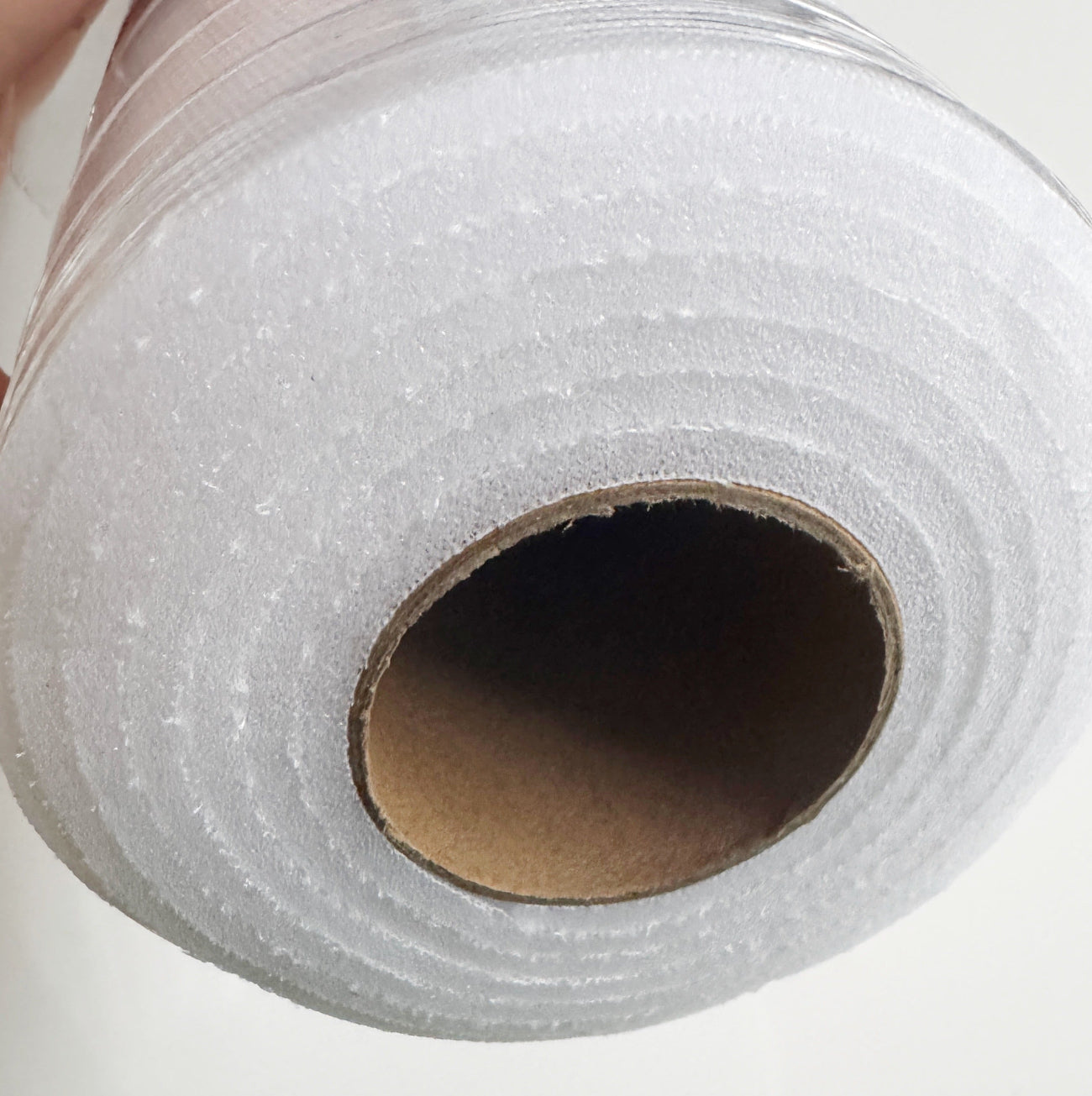 Roll of white foam stabilizer interfacing on white background