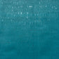 A close-up of a textured teal fabric with subtle horizontal and vertical brush-like striations and small white speckles.