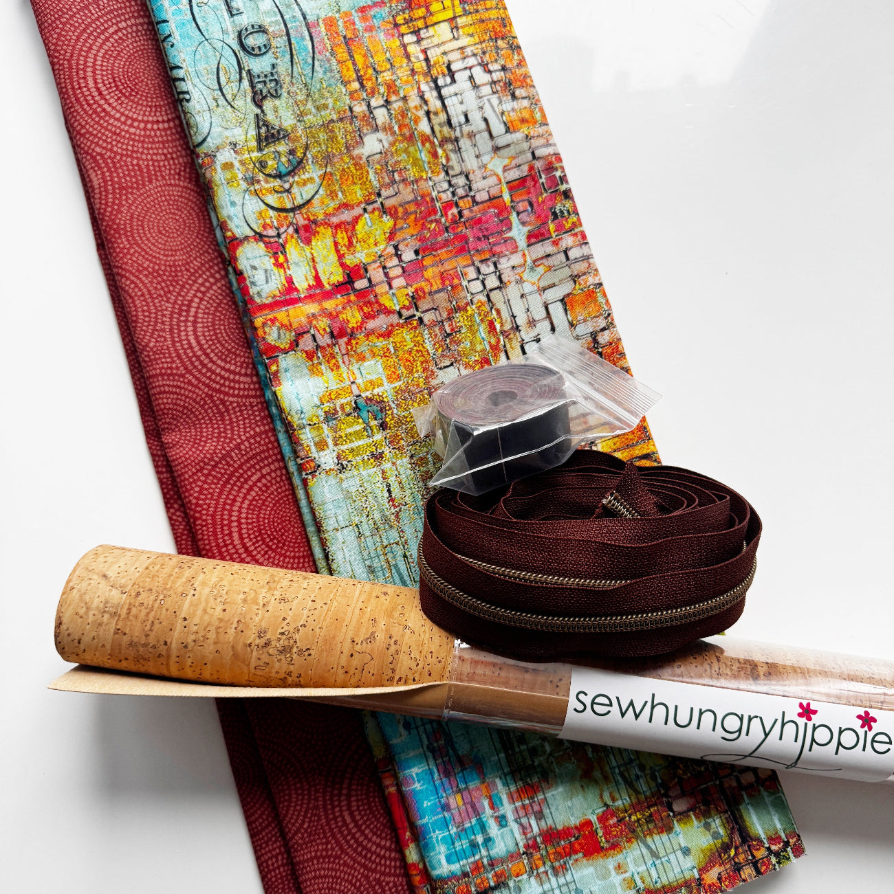Sewing bundle featuring Radiance fabric, cork fabric, leather strap, zipper tape, and artistic cotton fabric in warm brown tones