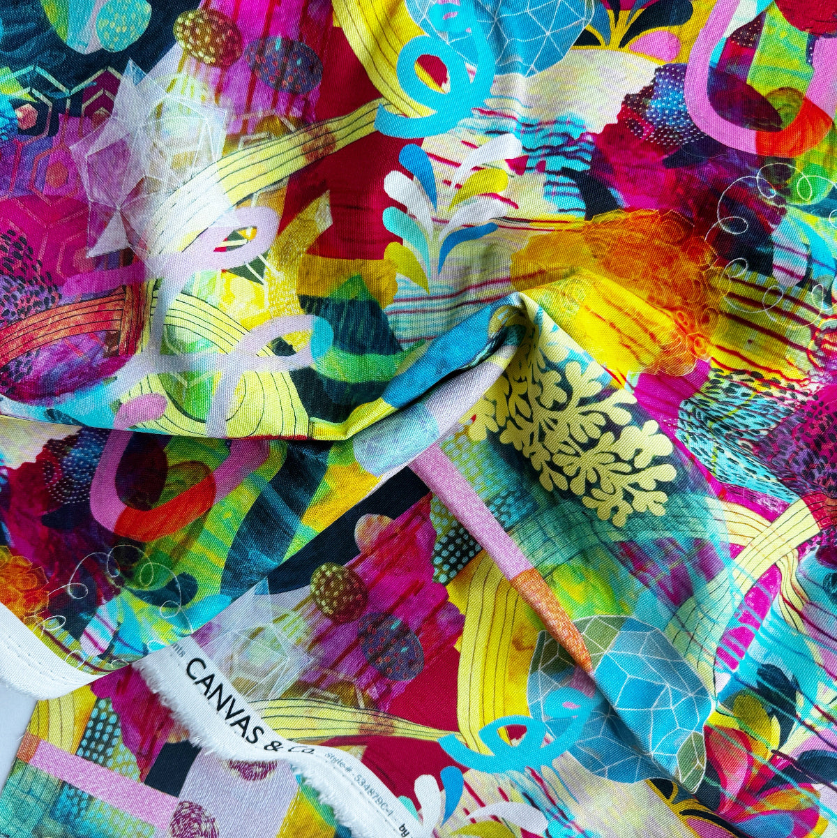 Colorful fabric with abstract patterns and a 'Canvas' label.