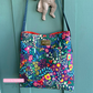 Colorful floral-patterned bag hanging on a teal door
