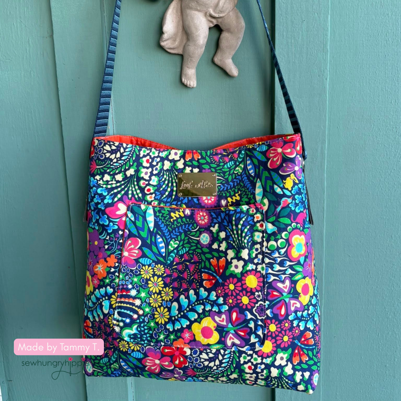 Colorful floral-patterned bag hanging on a teal door