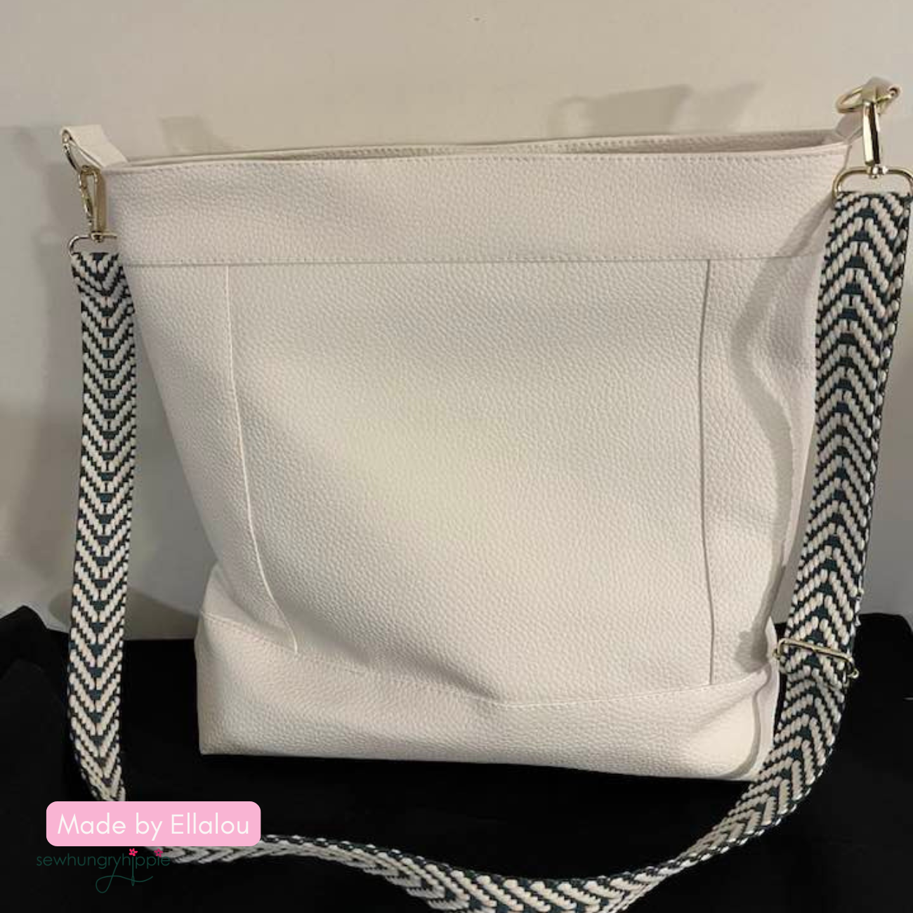 Stylish DIY Aspen Crossbody Bag sewn with white moonglow vinyl and black and white braided webbing with silver hardware for a trendy everyday bag.