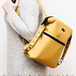 Yellow crossbody bag held by a person wearing a gray sweater on a white background. The Dainty Daytripper sewing pattern cover
