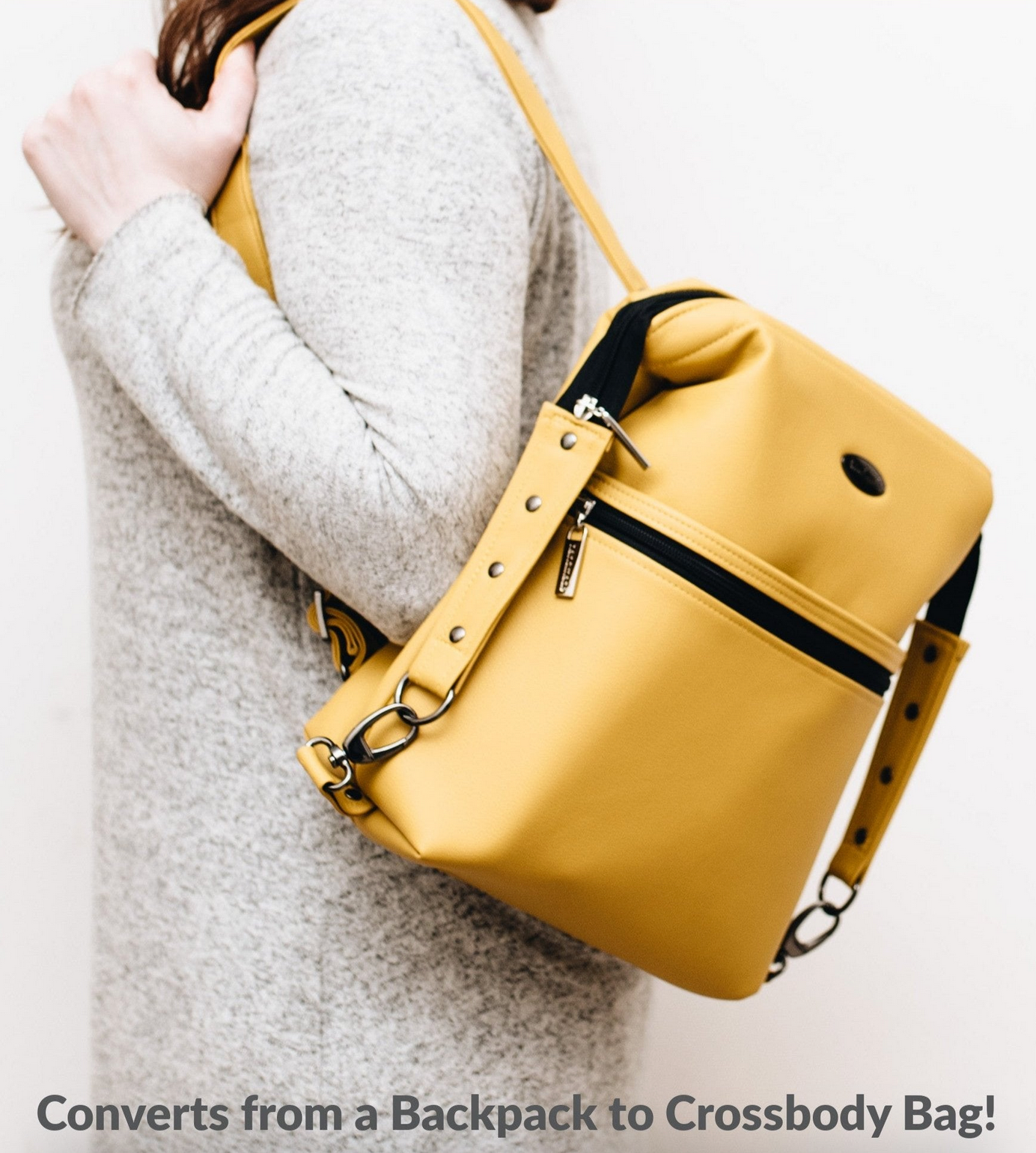Yellow convertible backpack being held by a person on a white background