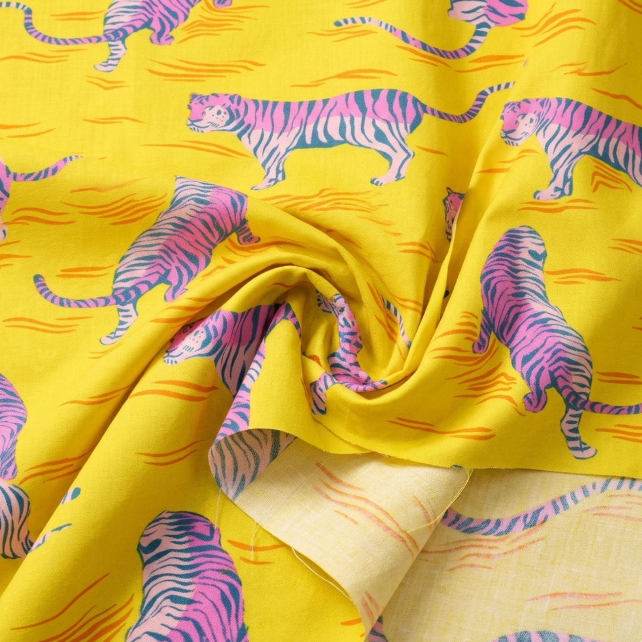 Pink tiger print cotton fabric on bright yellow background by Ruby Star Society, featuring retro-style striped tigers and abstract orange wave accents, shown in a soft draped fabric close-up perfect for quilting, sewing, apparel, and craft projects.
