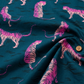 Pink tiger print cotton fabric on deep teal blue background by Ruby Star Society, shown in a soft draped close-up with flowing folds that highlight the smooth texture and retro animal print design for quilting, apparel, and sewing projects.