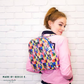 Young woman wearing a small Trina Backpack in colorful geometric print, made by Reece E.