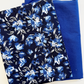 A coordinated fabric bundle for bag making featuring two folded materials: a dark navy blue bonded nylon exterior fabric printed with a vibrant blue, white, and gray floral pattern, paired with a matching solid bright royal blue polycotton lining fabric.