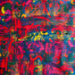 Close-up flat lay of an abstract print fabric with overlapping red, yellow, and blue geometric shapes on a textured, multi-colored background.