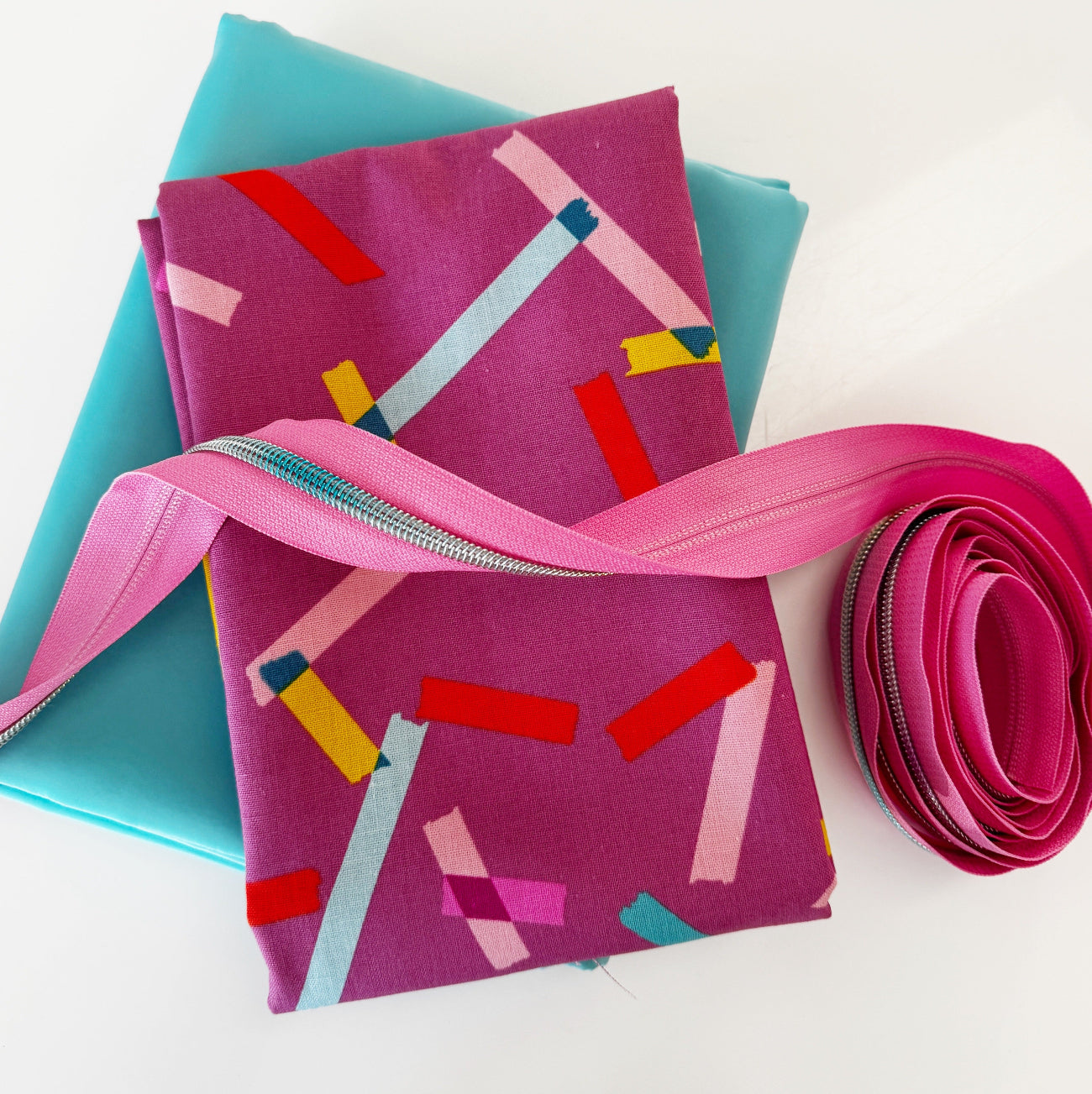 Confetti quilting cotton fabric paired with aqua canvas linen and pink zipper tape for sewing and bag making