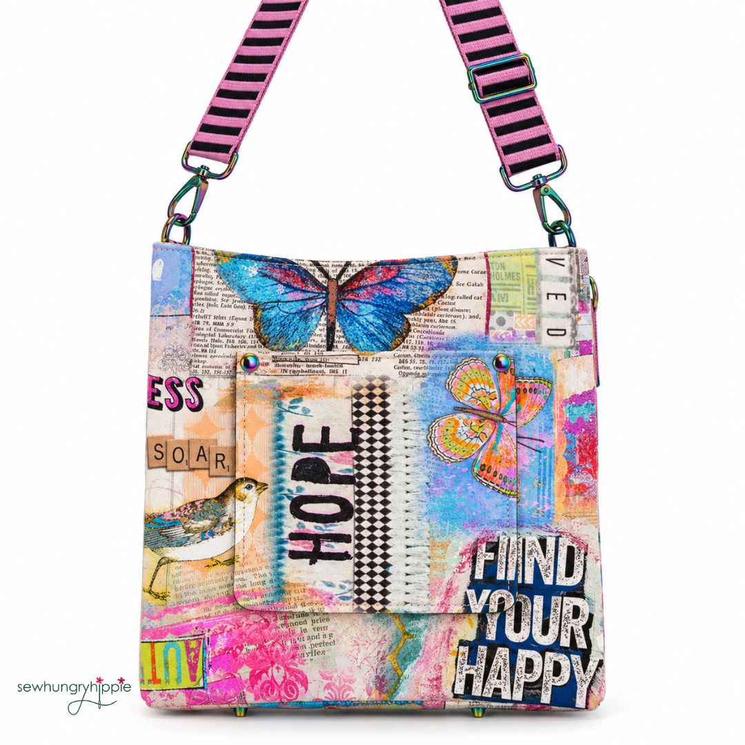A colorful crossbody bag with a vibrant collage print featuring butterflies, text, and a bird, complete with a pink and black striped shoulder strap.