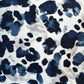 Pattern of blue and black spots on a white background