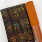 A roll of brown vegan leather and a folded yard of e Moda Tranquil Patina Luminary Stack in Earth 48116 13