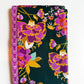 Art Gallery Fabrics two-piece fabric bundle featuring a dark teal quilting cotton with large, vibrant purple, magenta, and orange floral prints, paired with a coordinating magenta geometric wavy border fabric