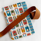 Bag print cotton fabric paired with coordinating blue geometric fabric and cognac leather bag strap for sewing handbags, totes, crossbody bags, and handmade accessories