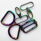 Five metallic hardware pieces iridescent rainbow finish, arranged on a plain white background.