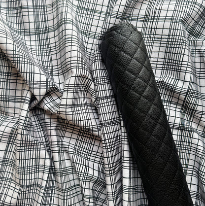 White fabric with black grid pattern paired with black diamond-quilted faux leather for bag making