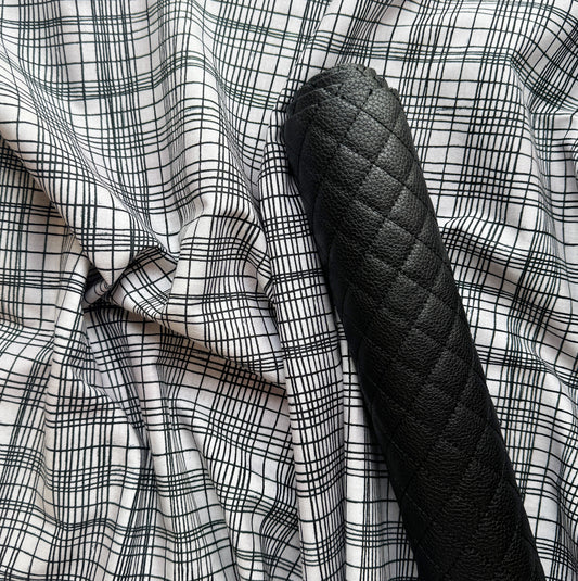 White fabric with black grid pattern paired with black diamond-quilted faux leather for bag making