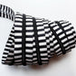 Black and white striped zipper with black nylon teeth shown coiled on a plain white background.