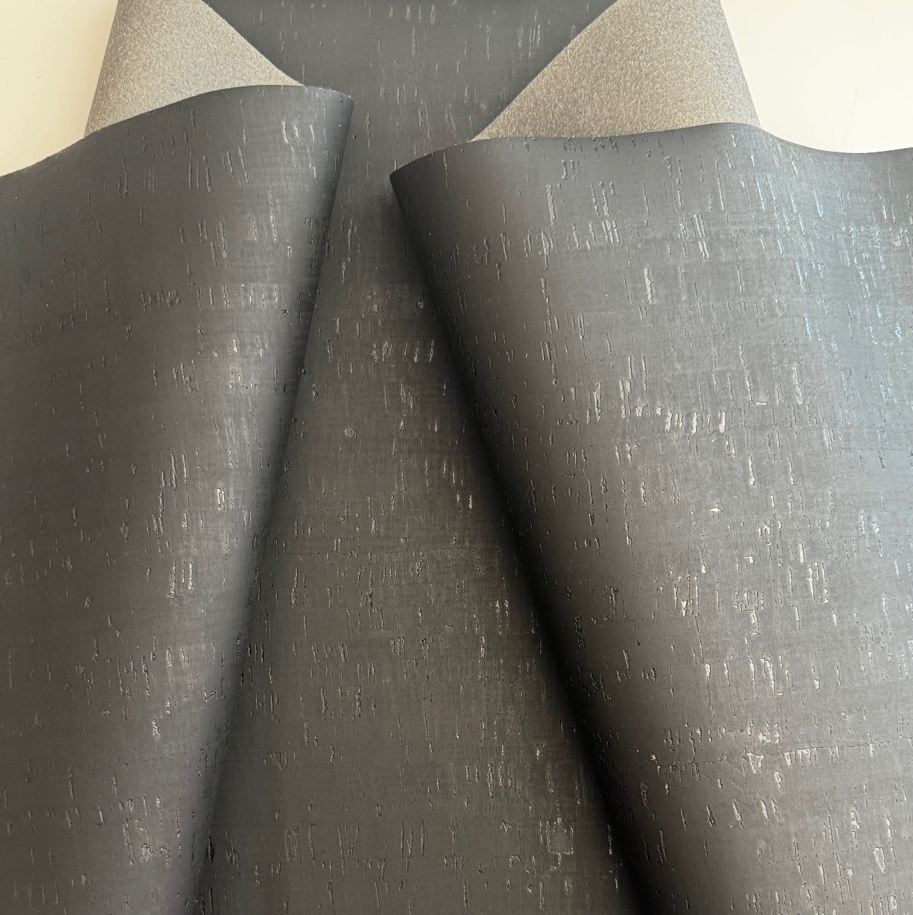 Black cork textured fabric on a neutral background