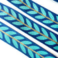 A blue and turquoise leaf-patterned jacquard ribbon trim with a central gold accent line for bag strap and webbing