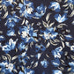 A close-up of a floral fabric pattern featuring blue, light blue, and white flowers with gray leaves on a dark navy background.