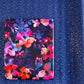 A pack of bonded nylon fabric with a vibrant pink, orange, and purple floral pattern on a dark background, set against a shimmering royal blue glitter vinyl sheet.