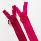 Color comparison of chunky zippers with circular ring pulls in bright pink on top and raspberry on the bottom