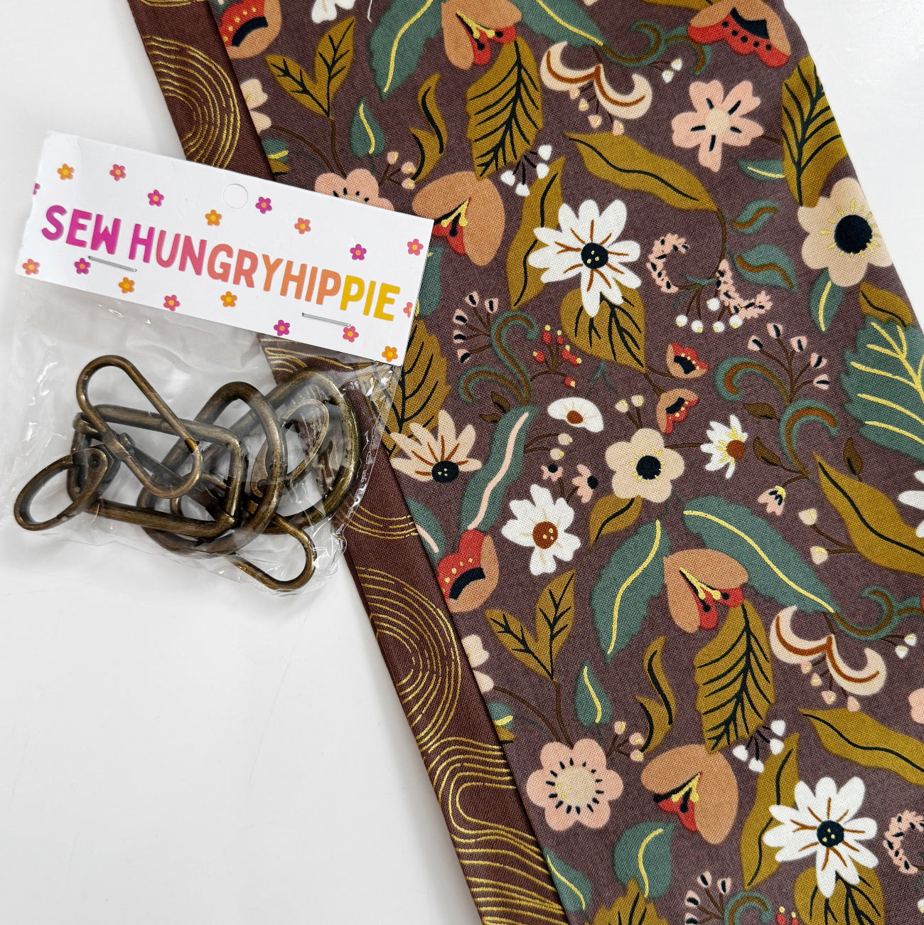 Brown floral cotton fabric with coordinating print and antique brass bag hardware for sewing handbags, crossbody bags, and handmade accessories.