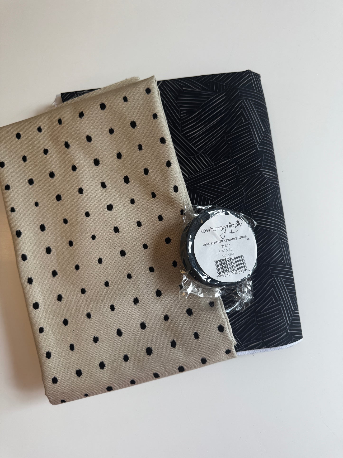 Sew Hungry Hippie Matchup 7 bundle including an abstract black bonded nylon pack, a yard of tan dotted fabric, and a black sewable leather strap