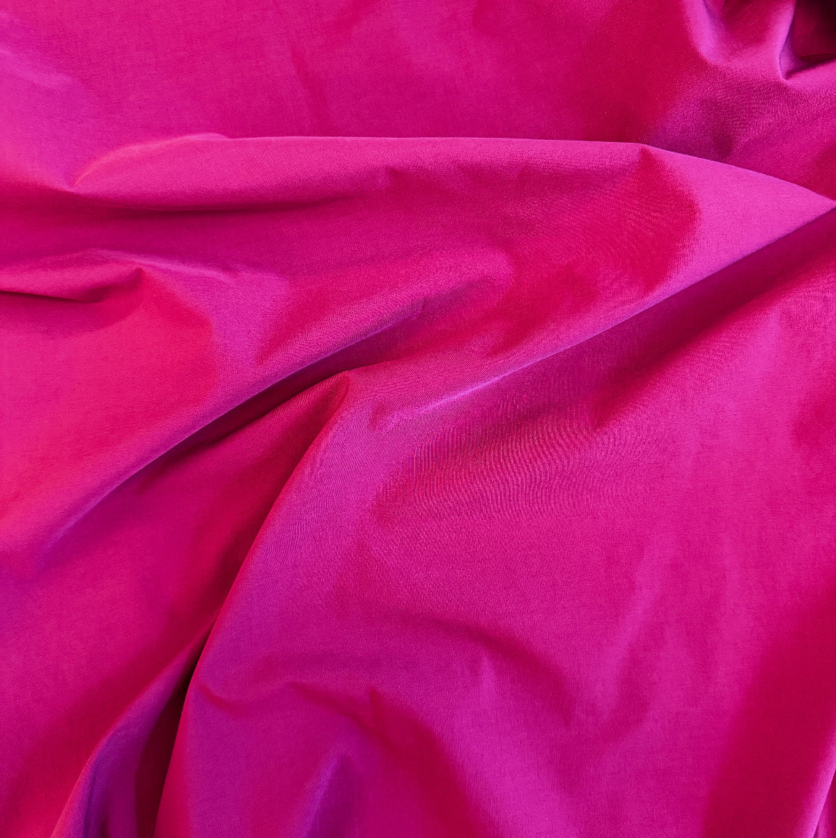 Close-up of bright pink fabric with folds