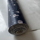 Roll of space-themed vinyl fabric on a light gray surface