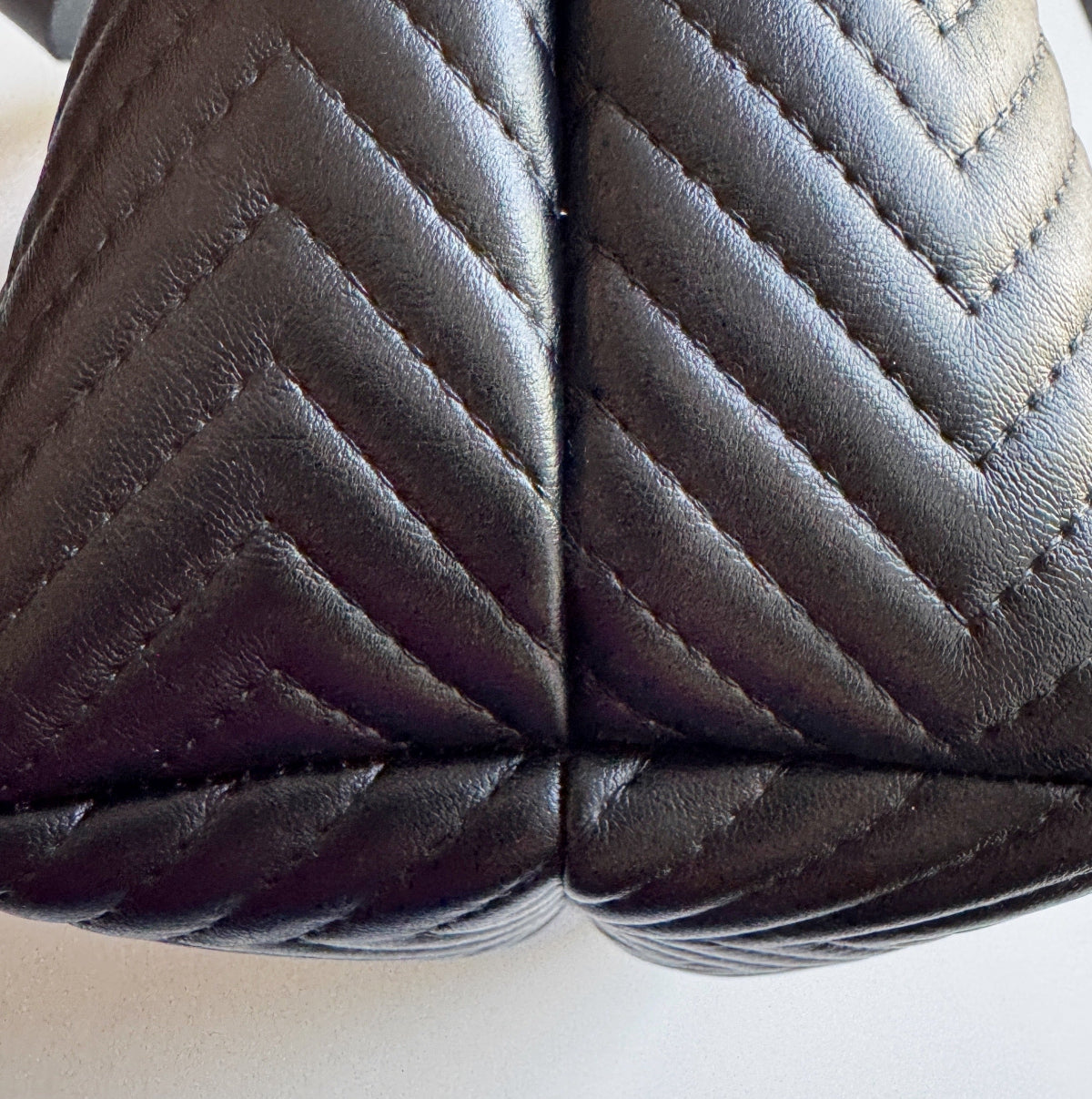 Close-up of black quilted leather handbag with visible stitching