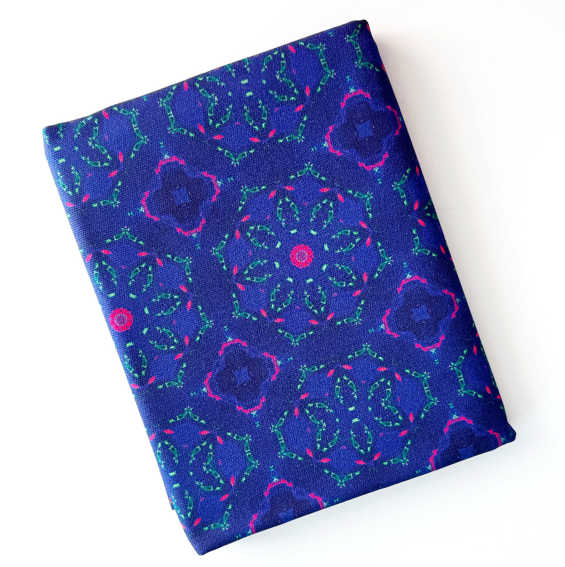 A folded piece of fabric with a vibrant blue, purple, and pink floral pattern, displayed on a clean white background.