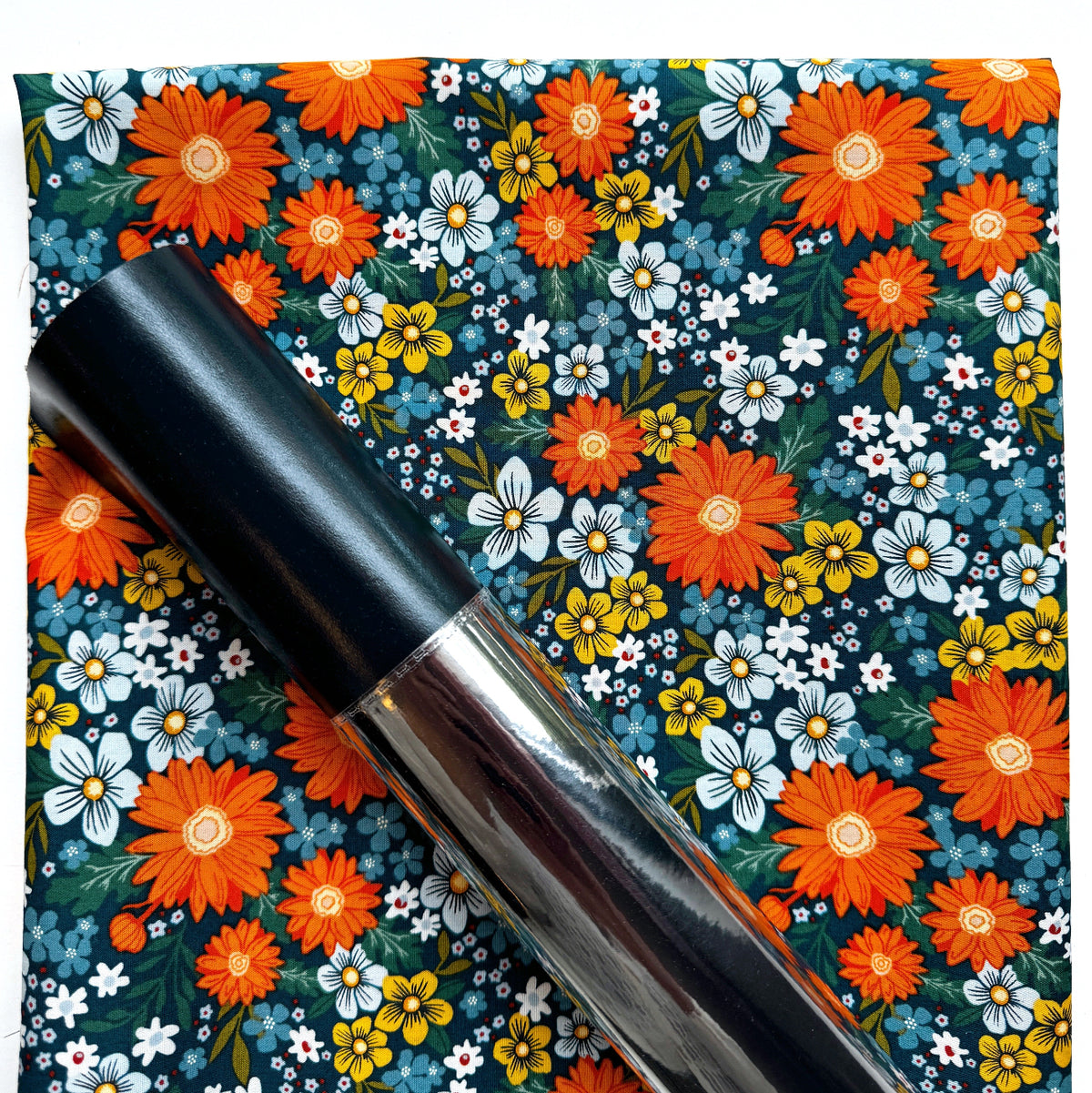 Dark teal fabric with retro orange daisies and small floral print for sewing projects