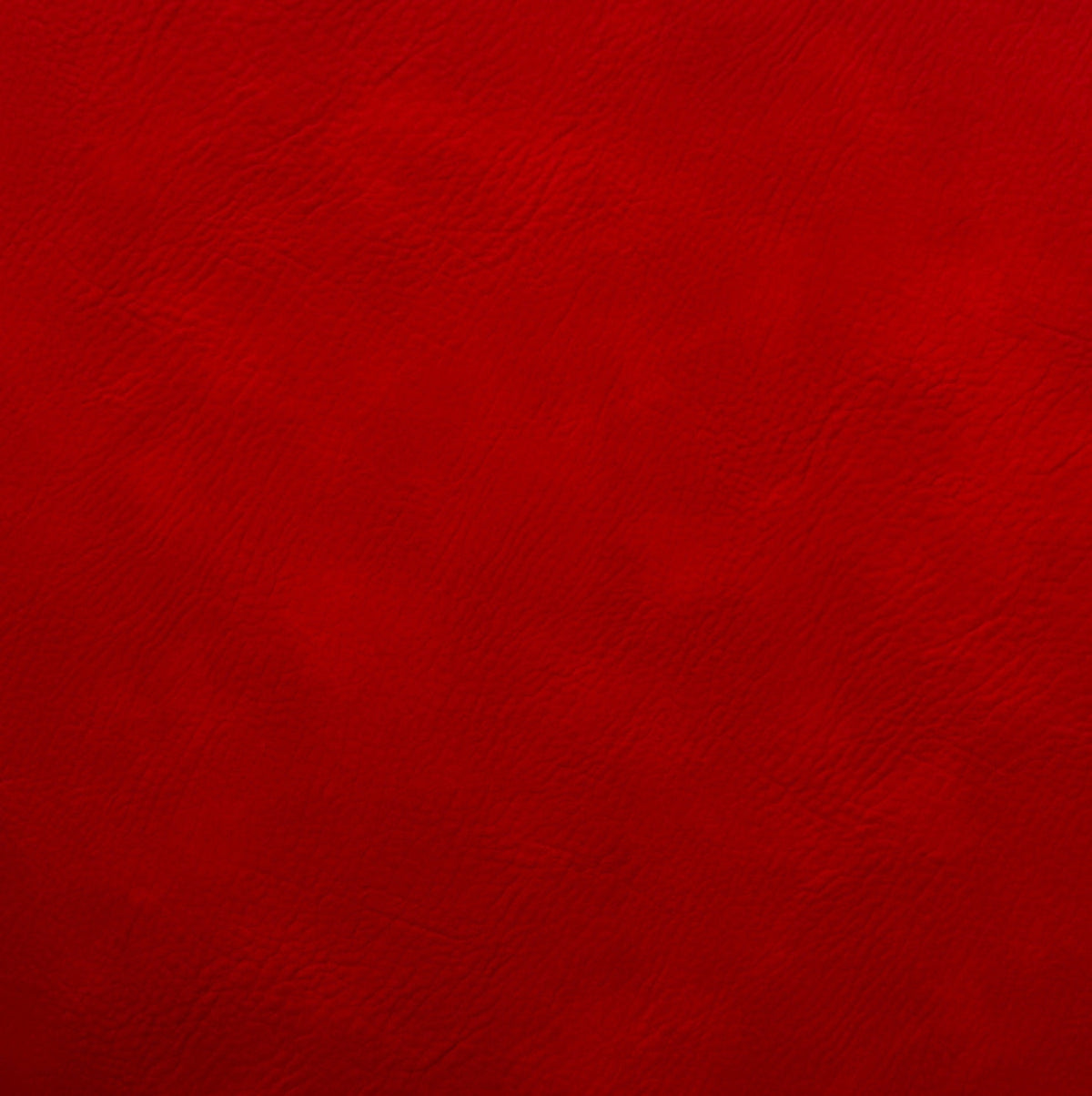 Close-up of deep red faux leather material featuring a fine natural grain texture with subtle crimson and burgundy color variations.