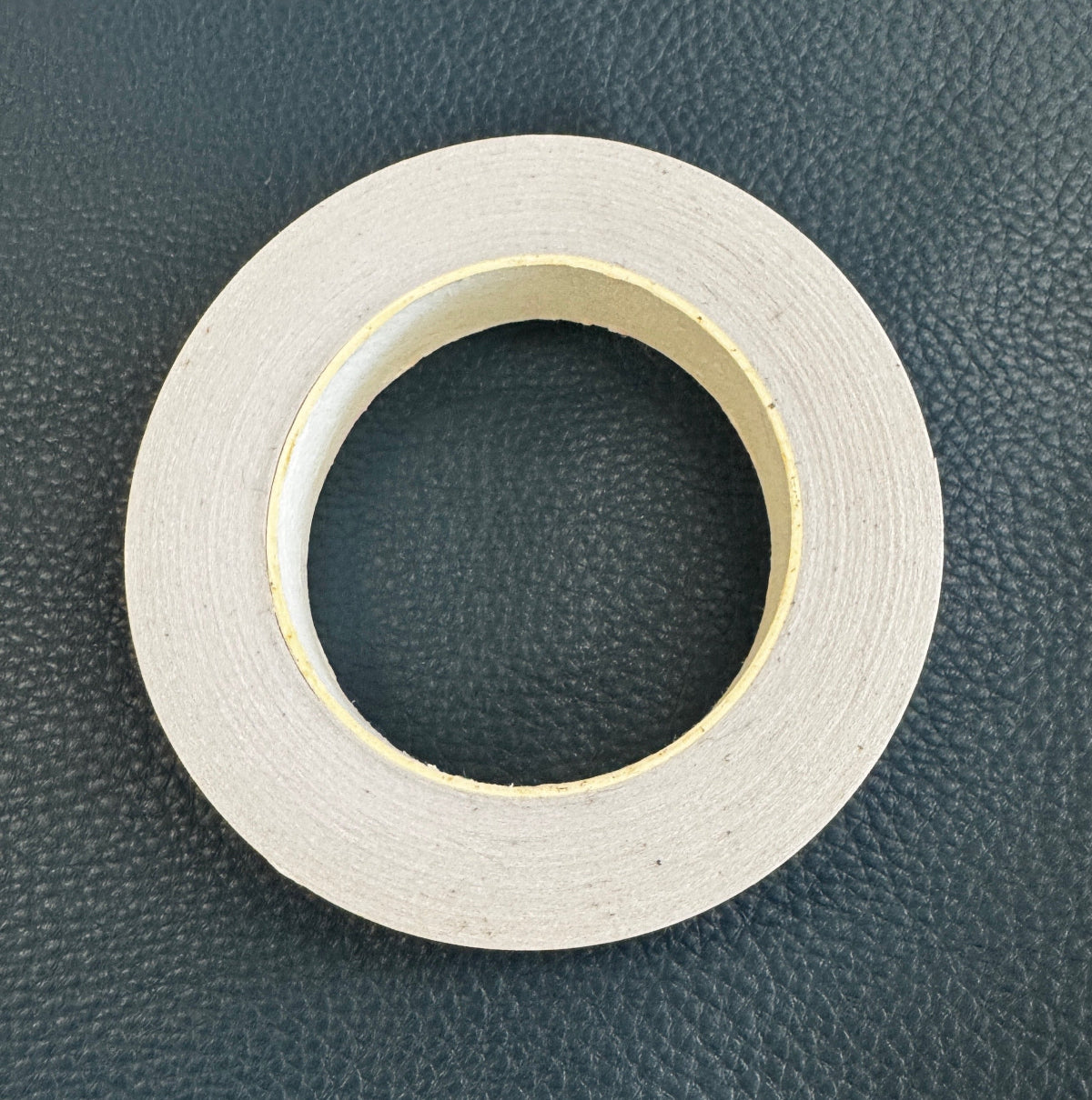 Roll of white tape on a dark textured background